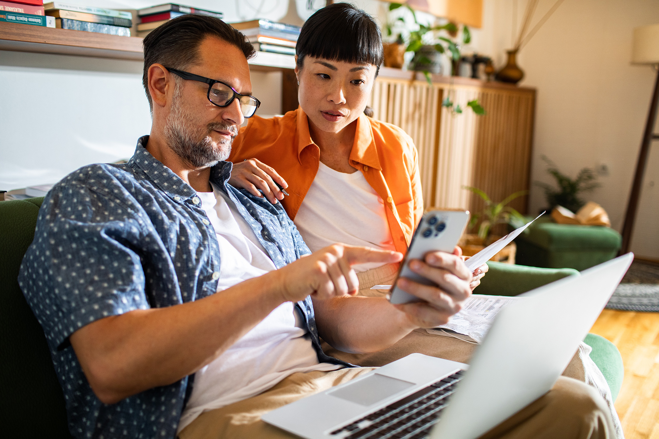 Couple managing finances and bills together on laptop
